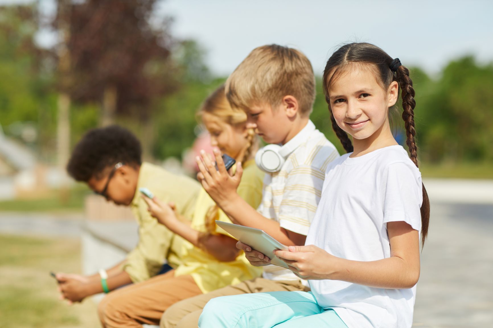 group-of-kids-using-gadgets-outdoors-2021-04-04-16-41-36-utc