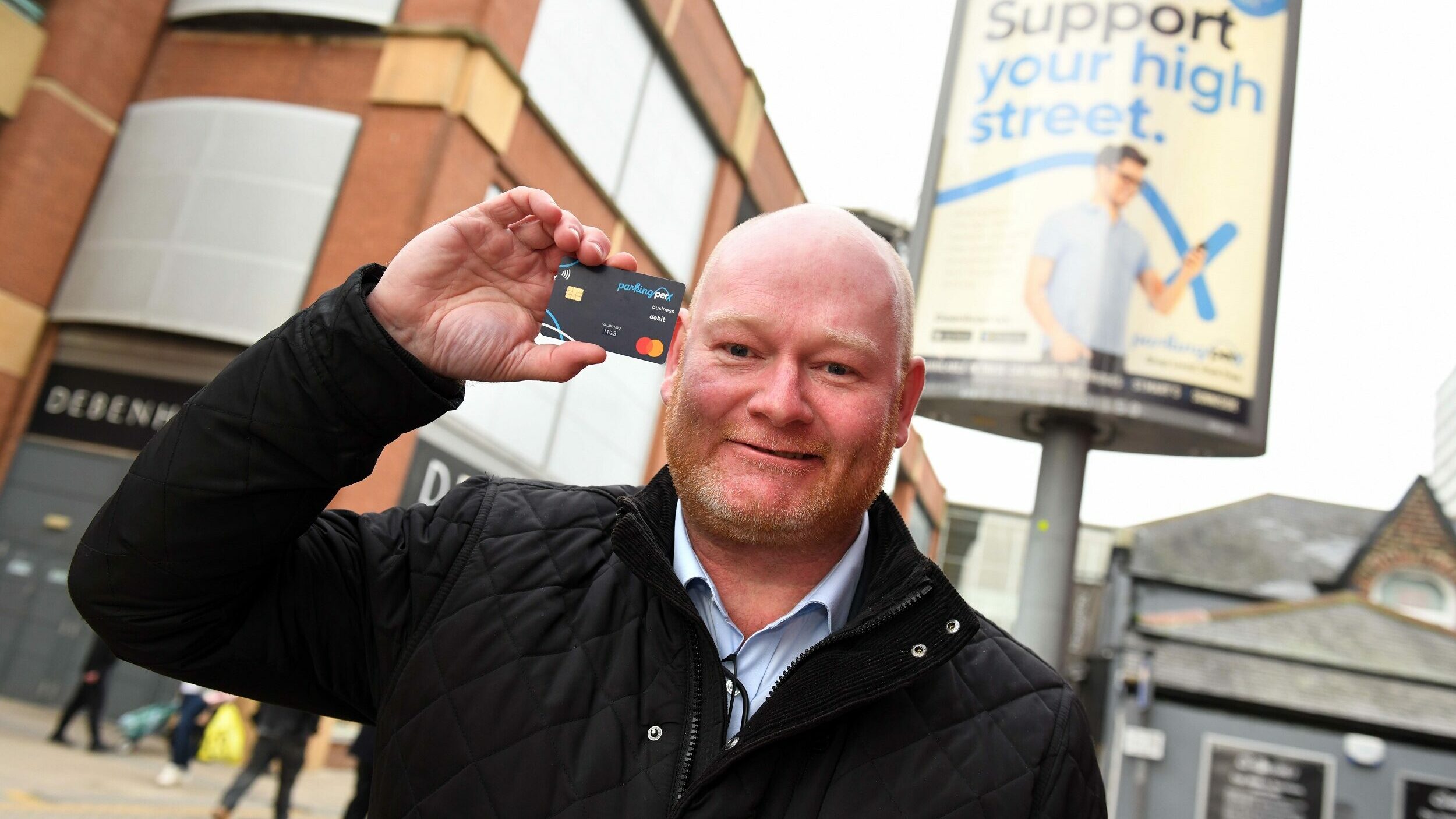 Chris Reed from ParkingPerx holding card up on highstreet